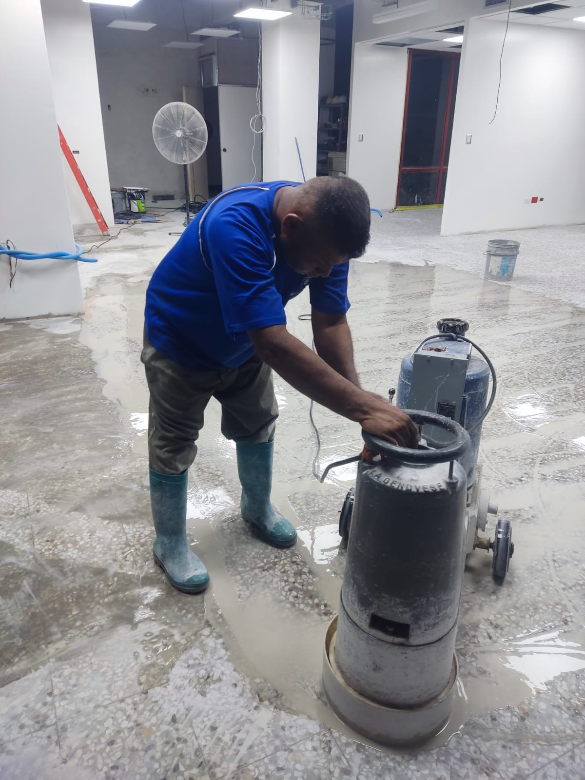 Técnico puliendo piso de piedra con maquinaria industrial
